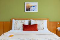 a bed with a red pillow and a green wall at Hotel Santorini in Vila Velha