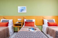 a hotel room with two beds with red pillows at Hotel Santorini in Vila Velha