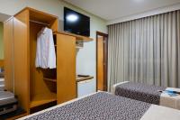 a hotel room with two beds and a tv at Hotel Santorini in Vila Velha