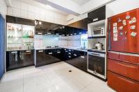 a large kitchen with black cabinets and a refrigerator at Sunny Homestay in Ji&#39;an