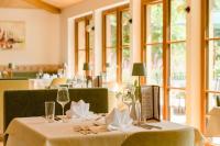 Un comedor con una mesa con vasos y servilletas. en Landhotel Hochlackenhof, en Fuschl am See