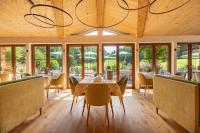 Un comedor con mesa y sillas y ventanas. en Landhotel Hochlackenhof, en Fuschl am See