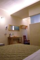a room with a bed and a desk with a phone at Hwa Hong Hotel in Kaohsiung