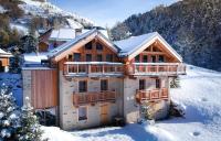 a log cabin in the snow with a balcony at Odalys Chalet Les Lions Blancs in Valloire