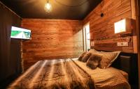 a bedroom with a bed in a room with wooden walls at Odalys Chalet Les Lions Blancs in Valloire