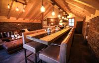 a bar with leather chairs and a table in a room at Odalys Chalet Les Lions Blancs in Valloire