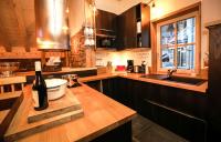 a kitchen with a bottle of wine on a counter at Odalys Chalet Les Lions Blancs in Valloire