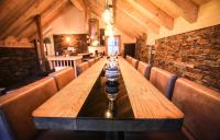 a long wooden table in a restaurant with chairs at Odalys Chalet Les Lions Blancs in Valloire