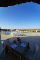 un tavolo e sedie su un patio con vista sull'oceano di GH Santina Resort & SPA a Valledoria