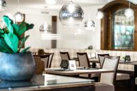 a restaurant with tables and chairs and a potted plant at Hotel Hubertushof in Anif