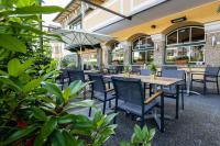 an outdoor patio with tables and chairs and plants at Hotel Hubertushof in Anif