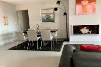 a living room with a table and chairs and a couch at Elegant Design Apt With Balcony And Pool in Porto-Vecchio
