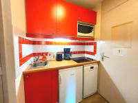 a small kitchen with red cabinets and a sink at Appartement La Plagne-Tarentaise, 1 pièce, 4 personnes - FR-1-351-146 in La Plagne Tarentaise
