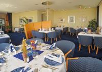 Un comedor con mesas y sillas azules. en Hotel Meerane, en Meerane