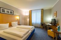 Una habitación de hotel con dos camas y un escritorio. en Waldhotel Eskeshof, en Wuppertal