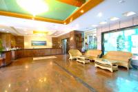 a lobby with chairs and tables in a building at Kenting Holiday Hotel in Hengchun South Gate