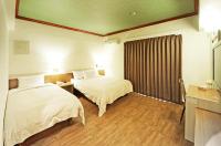 a hotel room with two beds and a window at Kenting Holiday Hotel in Hengchun South Gate