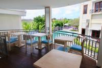 een balkon met tafels en stoelen en een zwembad bij Bali Karma Sajtra Hotel in Seminyak