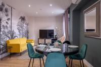 a living room with a table and green chairs at Appartements Emile Fourcand in Bordeaux
