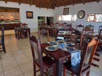 una sala da pranzo con tavolo e sedie in legno di Palm Afrique Lodge a Ghanzi