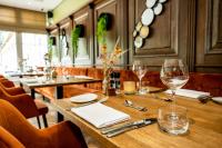 a table in a restaurant with wine glasses on it at Landhuis Hotel de Herikerberg in Markelo