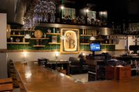 Un bar con un gran mostrador de madera en una habitación. en Graduate by Hilton Lincoln, en Lincoln