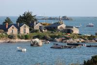 an island with houses and boats in the water at La Chanterie Agréable Mobil-Home Résidentiel Normand in Saint-Pair-sur-Mer