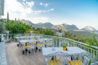 un balcón con mesas y sillas con montañas en el fondo en APA Mountain Lodge, en Antalya