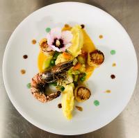 ein Teller mit Meeresfrüchten und einer Blume darauf in der Unterkunft Hôtel du Roy in Aisey-sur-Seine