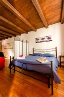 Cama grande en habitación con techo de madera en La Morra Flats, en La Morra