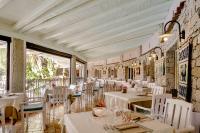 um restaurante com mesas e cadeiras brancas em Cruccùris Resort - Adults Only em Villasimius