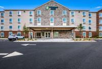Un gran edificio con un estacionamiento enfrente. en WoodSpring Suites Elgin - Chicago, en Elgin