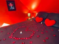 a bed with hearts on it with a red room at La Valentine Spa in Béthisy-Saint-Pierre