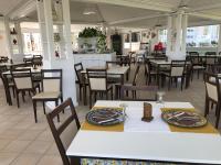 een eetkamer met tafels en stoelen in een restaurant bij Hotel Jonio in Noto Marina