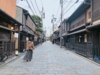 a woman walking down a street in an alley at Kyoto Inn Gion The Second in Kyoto