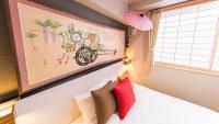 a bedroom with a bed with a painting on the wall at Kyoto Inn Gion The Second in Kyoto