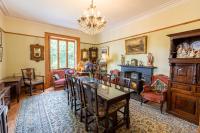 ein Wohnzimmer mit Tisch und Stühlen und einem Kamin in der Unterkunft Taldraeth - Old Vicarage Guest House in Penrhyndeudreath