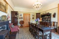 ein Esszimmer mit Tisch und Stühlen und einem Kronleuchter in der Unterkunft Taldraeth - Old Vicarage Guest House in Penrhyndeudreath