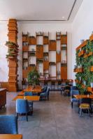 a waiting room with tables and chairs and plants at Canal Central Hotel Business Bay in Dubai