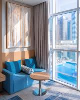 a living room with a blue couch and a large window at Canal Central Hotel Business Bay in Dubai