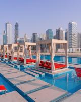 a row of boats in a pool with a city at Canal Central Hotel Business Bay in Dubai