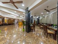 Un restaurante con mesas y sillas y un ventilador de techo. en Hotel Blooming Soul, en Kolhapur