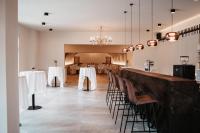 Un comedor con mesas y sillas blancas. en Schloss Gamlitz, en Gamlitz