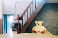 a teddy bear sitting on the floor under a staircase at Taipei Jinguashi Cloud Mountain Homestay B&amp;B in Jiufen