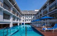 una piscina con sillas y sombrillas en un edificio en Royale Chulan Penang, en George Town