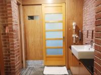 a bathroom with a sink and a wooden door at 建築師湧泉泡湯會館 in Dongshan