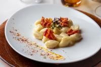 un plato blanco con pasta en una mesa en Cavallino Lovely Hotel, en Andalo