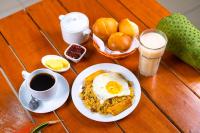 a table with a plate of breakfast food and a cup of coffee at Residencial Brest Amazon Tarapoto in Tarapoto