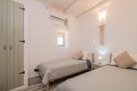 a bedroom with two beds and a cross on the wall at Villa Daniela in Koríthion
