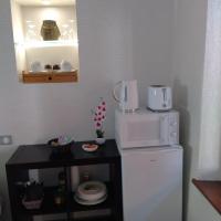 a small kitchen with a microwave on top of a refrigerator at Passage des Romains studio in Horbourg